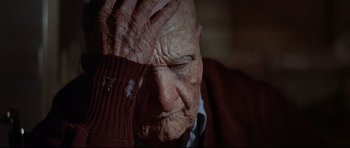 Movie still from “Little Big Man” (1970), directed by Arthur Penn – An old man with wrinkled skin holding his head; Close Up shot, Low angle