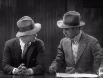 Movie still from “Little Caesar” (1931), directed by Mervyn LeRoy – A couple of men sitting next to each other at a table; Medium shot, High angle