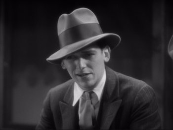 Movie still from “Little Caesar” (1931), directed by Mervyn LeRoy – A black and white photo of a man in a suit and a hat; Close Up shot, High angle