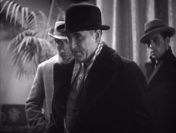 Movie still from “Little Caesar” (1931), directed by Mervyn LeRoy – An old photo of a man wearing a hat and a coat; Medium shot, Low angle