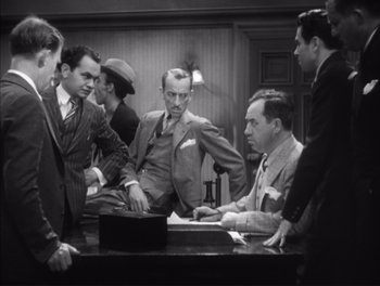 Movie still from “Little Caesar” (1931), directed by Mervyn LeRoy – A black and white photo of a group of men in suits; Medium shot, High angle