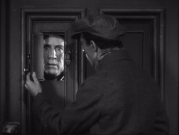 Movie still from “Little Caesar” (1931), directed by Mervyn LeRoy – A black and white photo of a man looking into a mirror; Medium shot, Low angle