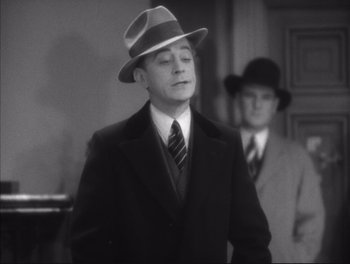 Movie still from “Little Caesar” (1931), directed by Mervyn LeRoy – A man in a suit and a hat standing next to another man in a suit and a hat; Medium shot, High angle