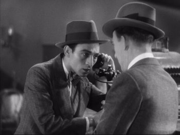 Movie still from “Little Caesar” (1931), directed by Mervyn LeRoy – A man in a suit and a man in a hat taking a picture of another man in a suit; Close Up shot, High angle