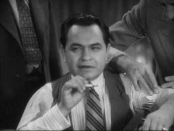 Movie still from “Little Caesar” (1931), directed by Mervyn LeRoy – A man in a suit and tie is brushing his teeth; Close Up shot, High angle