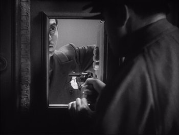 Movie still from “Little Caesar” (1931), directed by Mervyn LeRoy – A man holding a gun in front of a bathroom mirror; Close Up shot, Over the shoulder angle