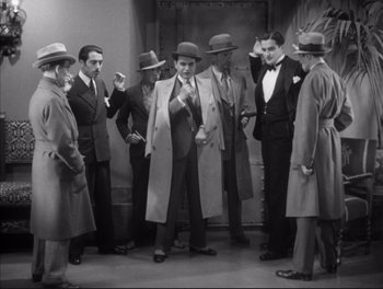 Movie still from “Little Caesar” (1931), directed by Mervyn LeRoy – A black and white photo of a group of men in suits and hats; Wide shot, High angle