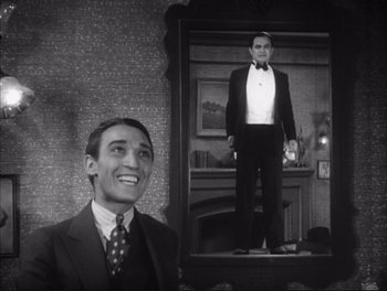 Movie still from “Little Caesar” (1931), directed by Mervyn LeRoy – A black and white photo of a man standing next to an image of himself; Medium shot, Low angle