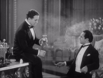 Movie still from “Little Caesar” (1931), directed by Mervyn LeRoy – Two men in suits are sitting in a room smoking; Medium shot, High angle