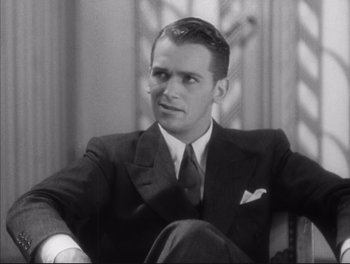 Movie still from “Little Caesar” (1931), directed by Mervyn LeRoy – A man sitting in a chair wearing a suit and tie; Close Up shot, Low angle