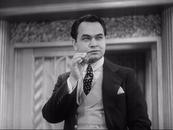 Movie still from “Little Caesar” (1931), directed by Mervyn LeRoy – A man in a suit and tie holding a cigarette; Close Up shot, Low angle