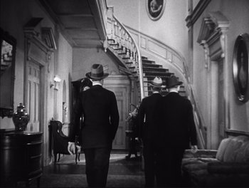 Movie still from “Little Caesar” (1931), directed by Mervyn LeRoy – A black and white photo of men in suits walking down a staircase; Wide shot, High angle