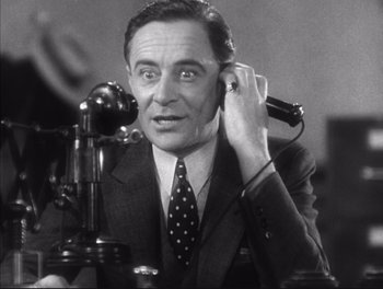 Movie still from “Little Caesar” (1931), directed by Mervyn LeRoy – An old photo of a man talking on a phone; Close Up shot, Low angle