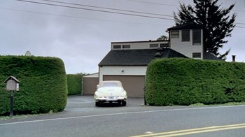 Movie still from “Little Dieter Needs to Fly” (1997), directed by Werner Herzog – A car is parked in the driveway of a house; Extreme Wide shot, Low angle