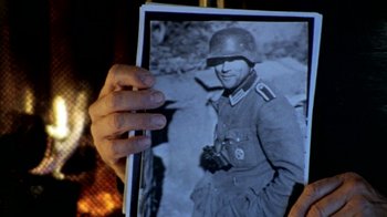 Movie still from “Little Dieter Needs to Fly” (1997), directed by Werner Herzog – A person holding a picture of a man in a uniform; Extreme Close Up shot, Overhead angle