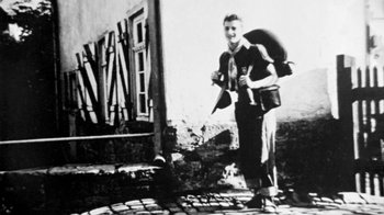 Movie still from “Little Dieter Needs to Fly” (1997), directed by Werner Herzog – An old black and white photo of a man with a bag on his back; Wide shot, Low angle