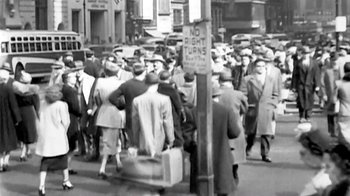 Movie still from “Little Dieter Needs to Fly” (1997), directed by Werner Herzog – A group of people walking down a street with suitcases; Wide shot, High angle