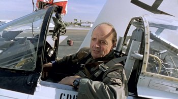 Movie still from “Little Dieter Needs to Fly” (1997), directed by Werner Herzog – A man sitting in the cockpit of an airplane; Medium shot, Low angle