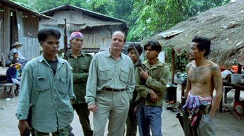 Movie still from “Little Dieter Needs to Fly” (1997), directed by Werner Herzog – A group of men standing next to each other on a street; Medium shot, Over the shoulder angle