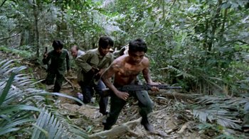 Movie still from “Little Dieter Needs to Fly” (1997), directed by Werner Herzog – A group of men in the woods with guns; Wide shot, High angle