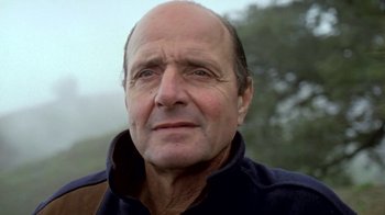 Movie still from “Little Dieter Needs to Fly” (1997), directed by Werner Herzog – An older man with a bald head wearing a blue jacket; Close Up shot, Low angle