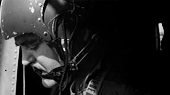 Movie still from “Little Dieter Needs to Fly” (1997), directed by Werner Herzog – A person with a microphone in a dark room; Close Up shot, Low angle