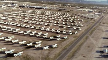 Movie still from “Little Dieter Needs to Fly” (1997), directed by Werner Herzog – An aerial view of a field with many white airplanes; Extreme Wide shot, High angle