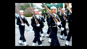 Movie still from “Little Dieter Needs to Fly” (1997), directed by Werner Herzog – A group of men in uniform marching down a street; Wide shot, Low angle