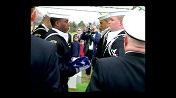 Movie still from “Little Dieter Needs to Fly” (1997), directed by Werner Herzog – A group of men holding a flag in front of a group of onlookers; Medium shot, Over the shoulder angle