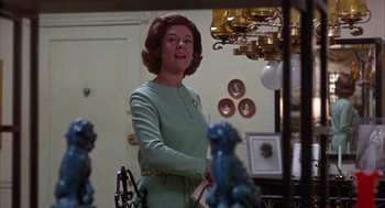 Movie still from “Little Murders” (1971), directed by Alan Arkin – An older woman standing in front of a chandelier in a living room; Medium shot, Low angle
