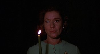 Movie still from “Little Murders” (1971), directed by Alan Arkin – A woman holding a lit candle in a dark room; Close Up shot, Low angle