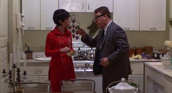 Movie still from “Little Murders” (1971), directed by Alan Arkin – A man and a woman standing in a kitchen talking; Medium shot, Low angle