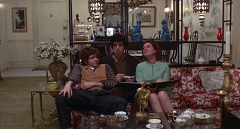 Movie still from “Little Murders” (1971), directed by Alan Arkin – A group of people sitting around a living room on couches; Medium shot, High angle