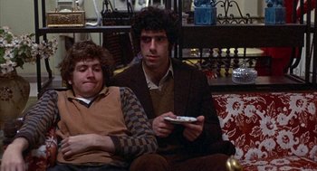 Movie still from “Little Murders” (1971), directed by Alan Arkin – Two men sitting on a couch holding a wii remote; Medium shot, High angle