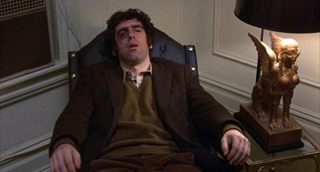 Movie still from “Little Murders” (1971), directed by Alan Arkin – A man sitting in a chair with his eyes closed; Medium shot, High angle