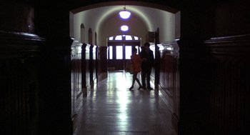 Movie still from “Little Murders” (1971), directed by Alan Arkin – Two people are standing in the hallway of a building; Wide shot, Low angle