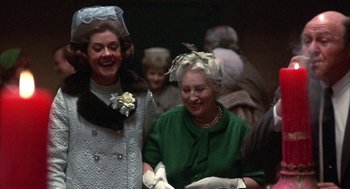 Movie still from “Little Murders” (1971), directed by Alan Arkin – Two older women are laughing together at an event; Medium shot, Low angle