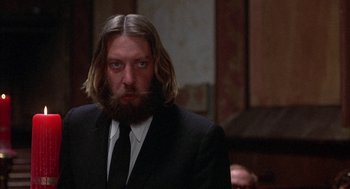Movie still from “Little Murders” (1971), directed by Alan Arkin – A man with long hair and a beard in a suit; Close Up shot, Low angle