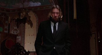 Movie still from “Little Murders” (1971), directed by Alan Arkin – A man with long hair and a beard wearing a suit; Medium shot, Low angle