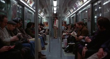 Movie still from “Little Murders” (1971), directed by Alan Arkin – A group of people sitting on a subway train; Wide shot, High angle