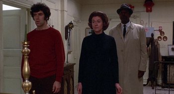 Movie still from “Little Murders” (1971), directed by Alan Arkin – A group of people standing in a room; Medium shot, Low angle