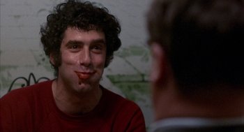 Movie still from “Little Murders” (1971), directed by Alan Arkin – A man with a red shirt is looking at another man with a red shirt; Close Up shot, Over the shoulder angle