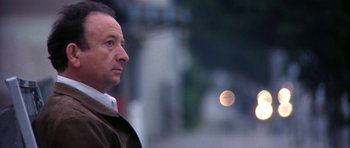 Movie still from “Little Odessa” (1994), directed by James Gray – A person standing near a street; Close Up shot, Low angle