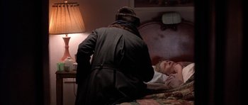 Movie still from “Little Odessa” (1994), directed by James Gray – An old woman laying in bed with a man; Medium shot, High angle