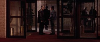 Movie still from “Little Odessa” (1994), directed by James Gray – A group of men standing next to each other in front of an elevator; Wide shot, Over the shoulder angle