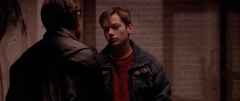 Movie still from “Little Odessa” (1994), directed by James Gray – A man in a red shirt and a blue jean jacket; Close Up shot, Over the shoulder angle