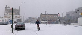 Movie still from “Little Odessa” (1994), directed by James Gray – A man riding a bike through the snow; Extreme Wide shot, Low angle