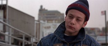 Movie still from “Little Odessa” (1994), directed by James Gray – A young man wearing a denim jacket and a red and blue hat; Close Up shot, Low angle