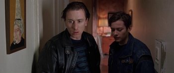 Movie still from “Little Odessa” (1994), directed by James Gray – A man wearing a leather jacket next to another man in a room; Close Up shot, Low angle