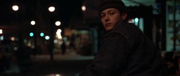 Movie still from “Little Odessa” (1994), directed by James Gray – A young man in a hat and a jacket is standing in the dark; Close Up shot, Low angle